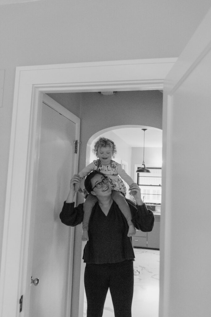 Mom with daughter on shoulders at home photo session Iowa City IA
