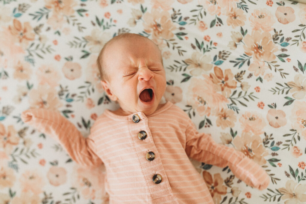 Baby portrait yawning in bed at home in Tiffin Iowa