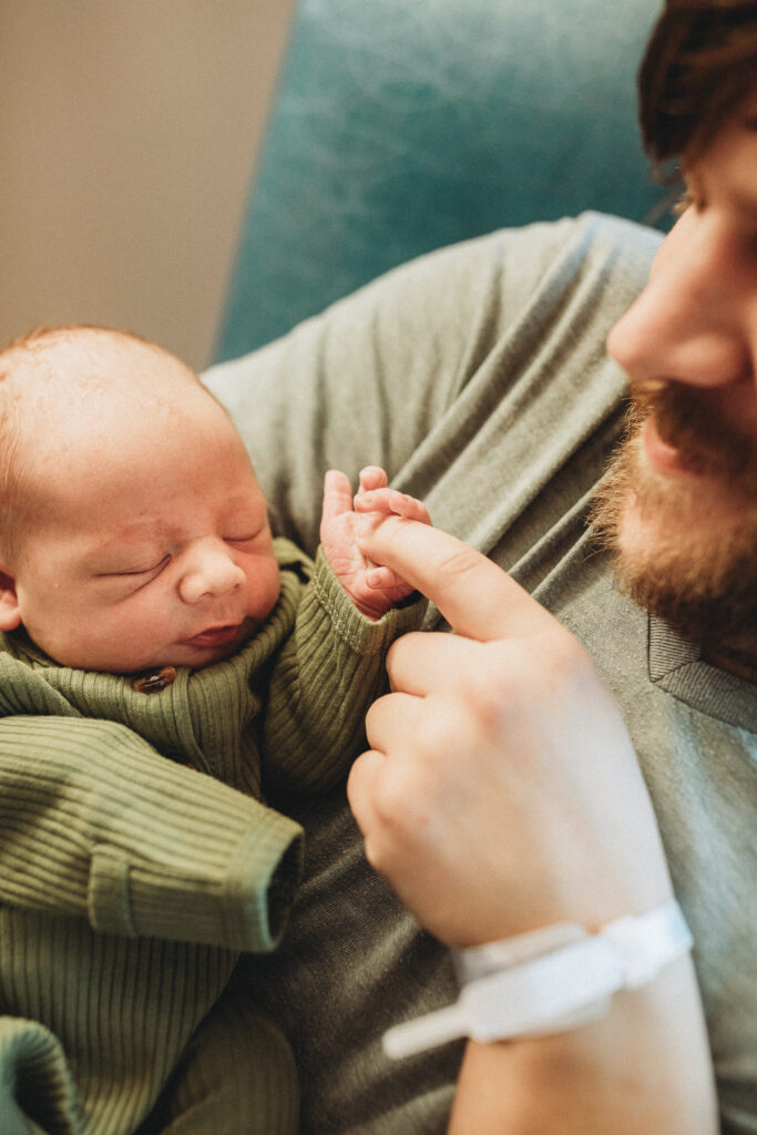 baby holding dad's finger