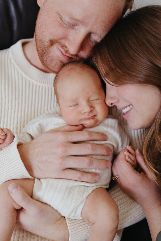 mom and dad with newborn baby at home in iowa city, ia