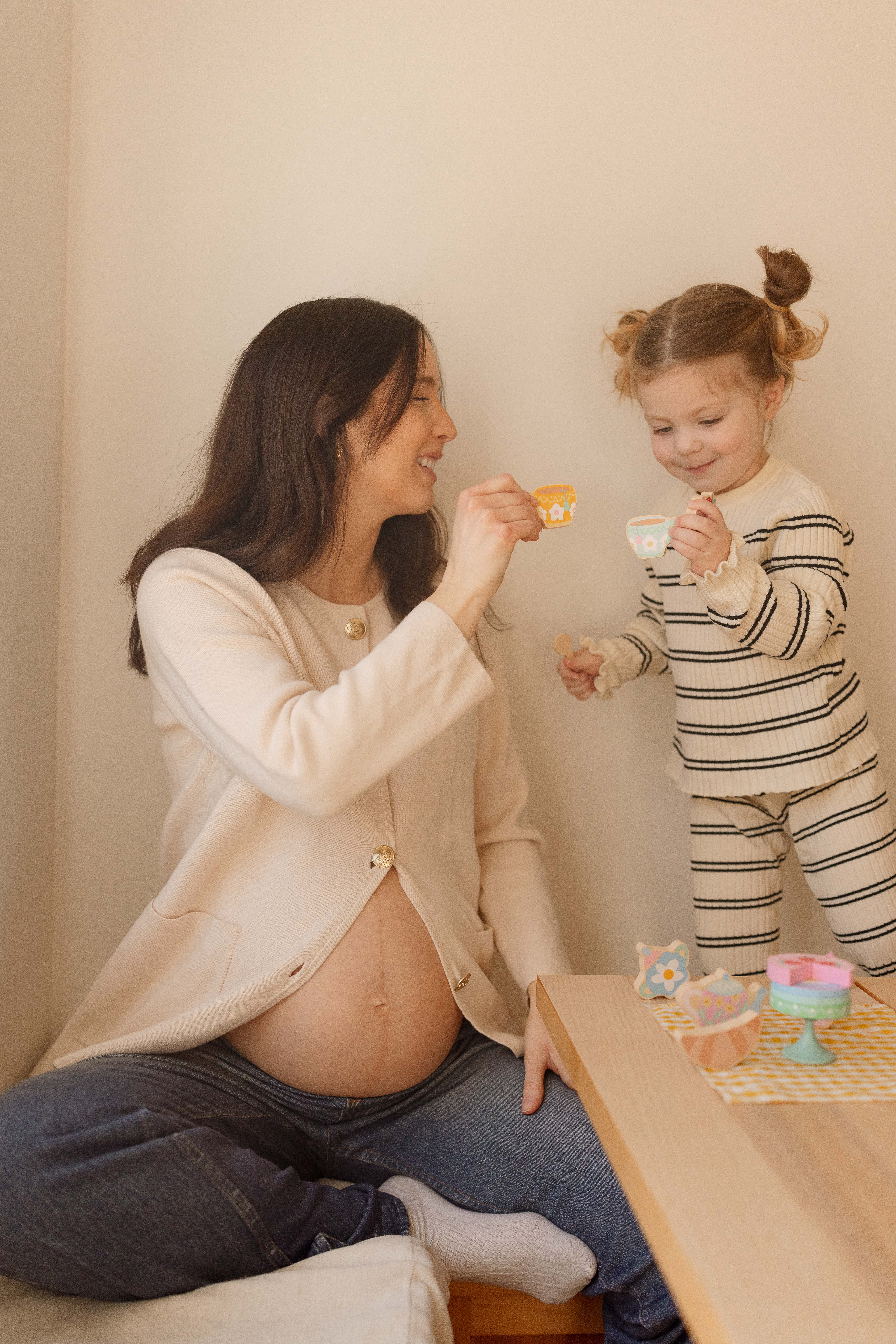 mom and daughter tea party during maternity photos at home iowa city